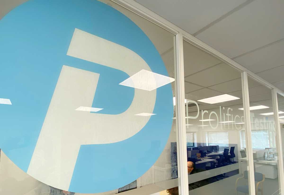 A section of the office that has glass doors with Prolifics Testing and the logo across it