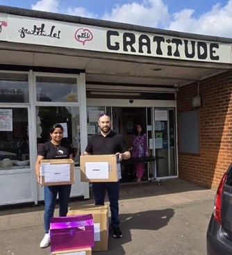 Two of our staff members holding the items to be donated in front of the charity