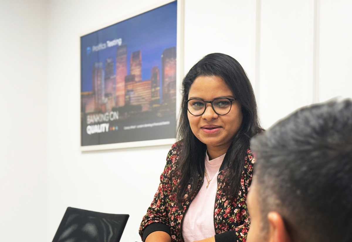 Prolifics Testing consultant in discussion with a colleague in a meeting room