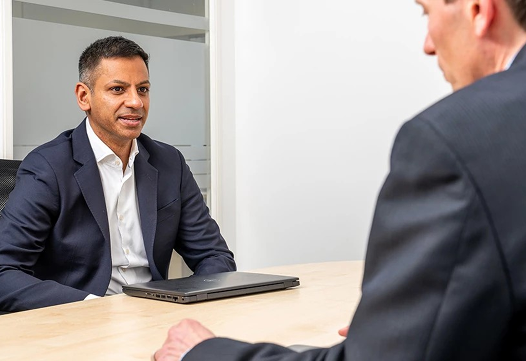 Two business people sitting across a table in a meeting
