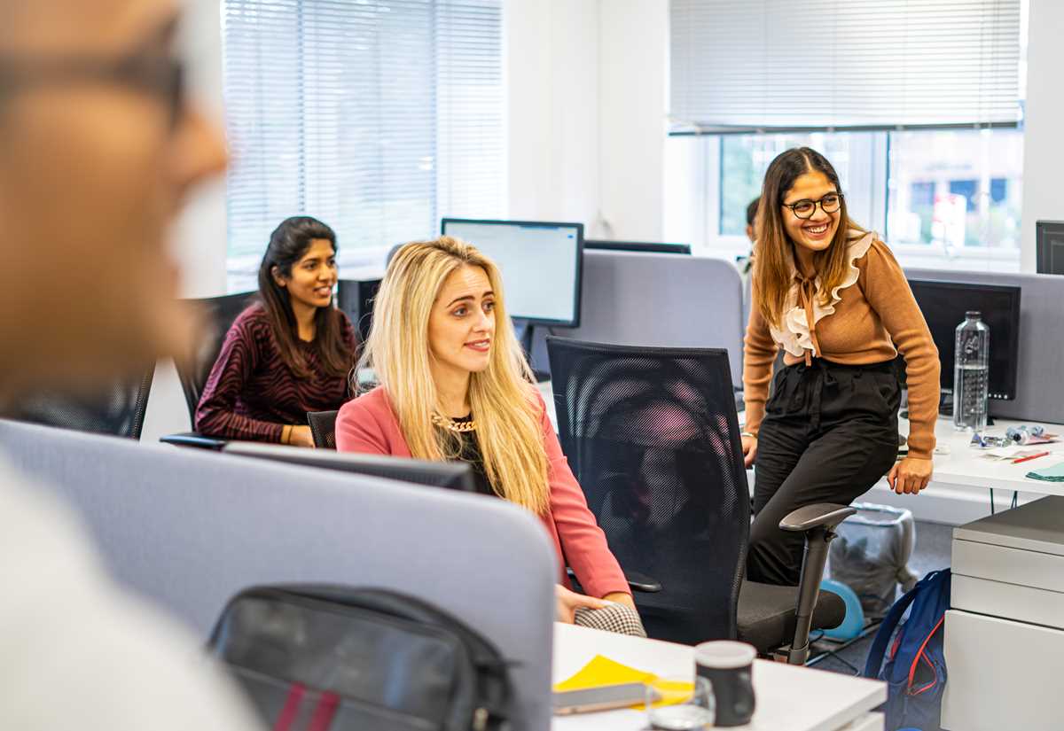 Smiling colleagues working at their desks in an open-plan office