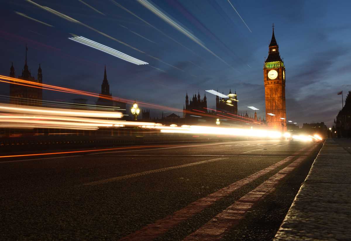Big Ben in London with traffic roaring past.